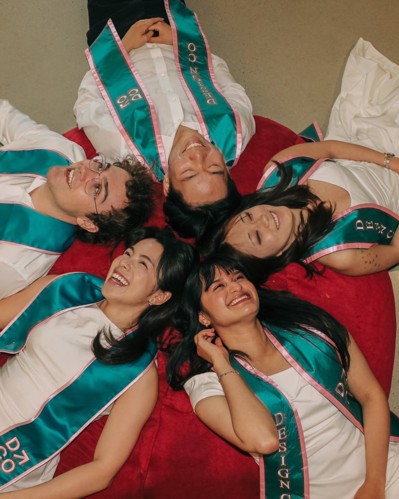 Luca Pfister and friends celebrating graduation on a red beanbag